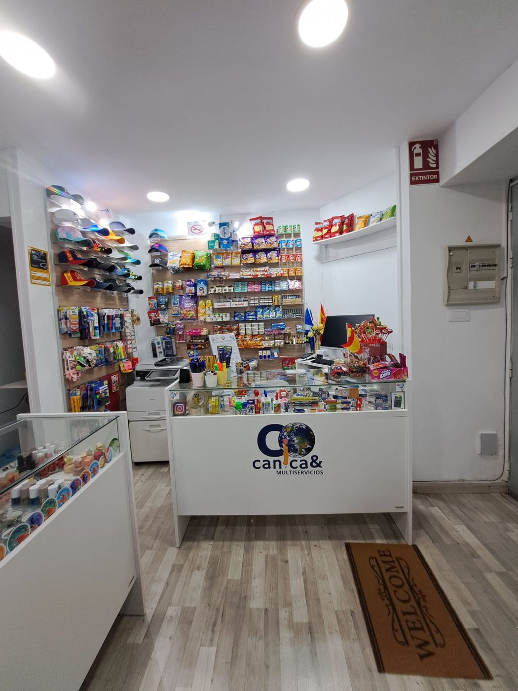 Interior de Canica& Multiservicios: mostrador con el logotipo y estanterías de productos